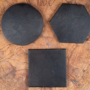 Peut inclure: Trois sous-verres noirs en pierre naturelle. Les sous-verres sont de formes différentes : rond, carré et hexagonal.
