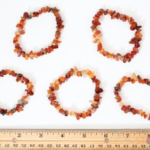 Carnelian chip bracelet. These tumbled chips range in color from orange to red, are drilled and strung on an elastic cord, and create an endless bracelet.