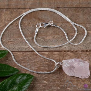 These pale pink Rose Quartz crystal jewelry sets are raw crystal chunk pendants strung on a silver chain, with matching earrings on silver ear hooks.  
Crystals are nature-made therefore each one is unique in appearance.