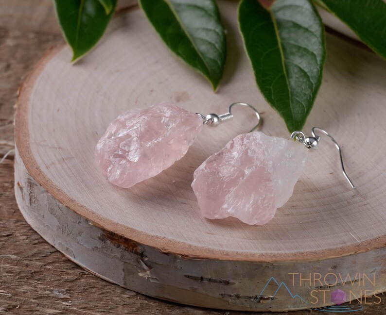 These pale pink Rose Quartz crystal jewelry sets are raw crystal chunk pendants strung on a silver chain, with matching earrings on silver ear hooks.  
Crystals are nature-made therefore each one is unique in appearance.