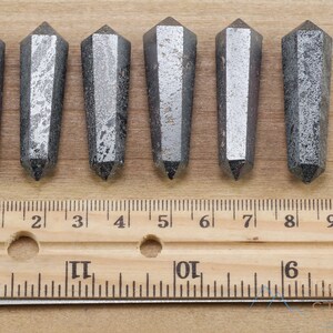 Hematite Mini Crystal Points. These metallic grey miniature wands are double terminated with a polished finish. Each gemstone is unique and will vary in size, shape, and color. These miniature points are great for jewelry making and crystal decor.