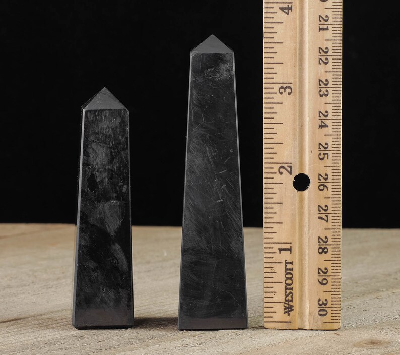 Shungite Crystal Tower. These genuine obelisk shaped crystal carvings are black with a polished finish and are great for crystal grids and decor. Each faceted crystal point is unique and will vary in size, shape, and color. Listing has variations.