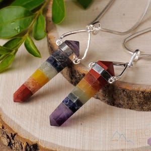 These rainbow chakra crystal pendants are polished double terminated points held in a silver bail.  The points are a composite of different crystals.
Crystals are nature-made therefore each one is unique in appearance.