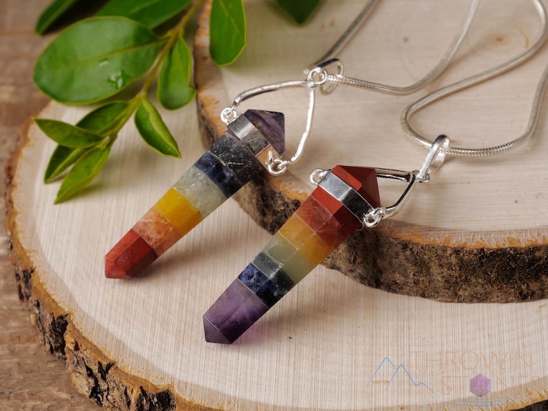 These rainbow chakra crystal pendants are polished double terminated points held in a silver bail.  The points are a composite of different crystals.
Crystals are nature-made therefore each one is unique in appearance.