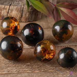 Genuine Amber Crystal Spheres. These semi precious orange crystal balls are between 15 and 40 millimeters in diameter and weigh between 1 and 40 grams. This listing has variations and only medium large and extra large spheres will come with a stand.