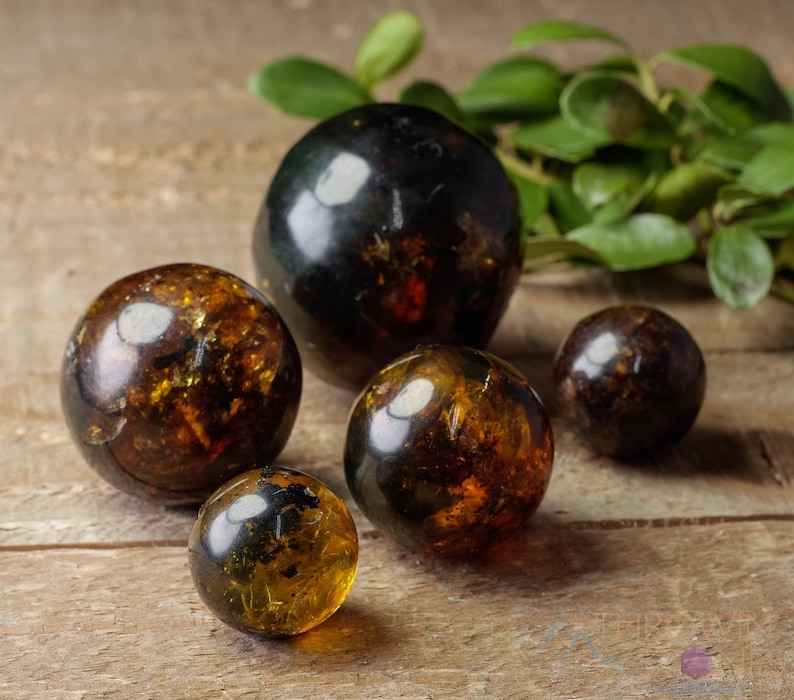 Genuine Amber Crystal Spheres. These semi precious orange crystal balls are between 15 and 40 millimeters in diameter and weigh between 1 and 40 grams. This listing has variations and only medium large and extra large spheres will come with a stand.