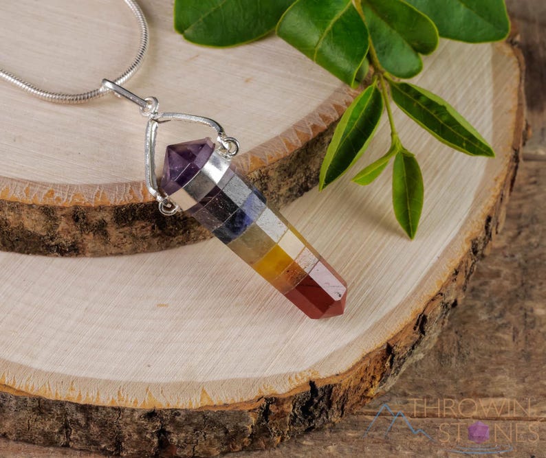 These rainbow chakra crystal pendants are polished double terminated points held in a silver bail.  The points are a composite of different crystals.
Crystals are nature-made therefore each one is unique in appearance.
