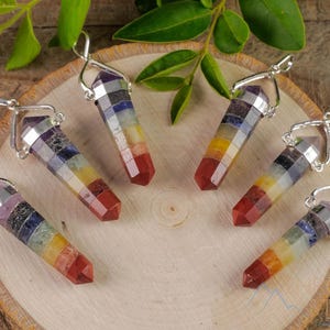 These rainbow chakra crystal pendants are polished double terminated points held in a silver bail.  The points are a composite of different crystals.
Crystals are nature-made therefore each one is unique in appearance.