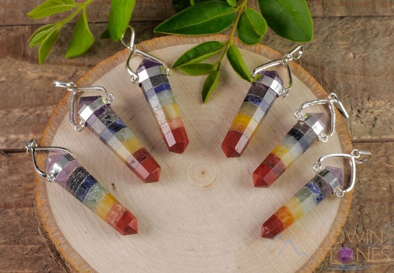 These rainbow chakra crystal pendants are polished double terminated points held in a silver bail.  The points are a composite of different crystals.
Crystals are nature-made therefore each one is unique in appearance.