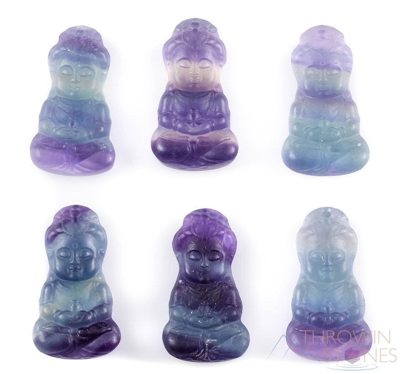 These rainbow Fluorite crystal pendants are carved in the shape of seated Buddha, with a small hole drilled.  Rainbow Fluorite is striated in sheer green, teal, and purple.
Crystals are nature-made therefore each one is unique in appearance.