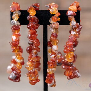 Carnelian chip bracelet. These tumbled chips range in color from orange to red, are drilled and strung on an elastic cord, and create an endless bracelet.