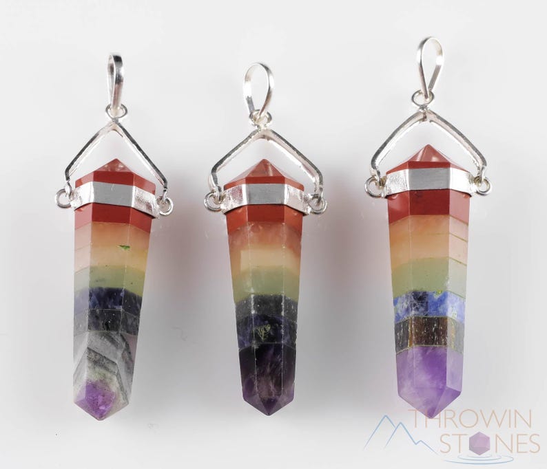 These rainbow chakra crystal pendants are polished double terminated points held in a silver bail.  The points are a composite of different crystals.
Crystals are nature-made therefore each one is unique in appearance.