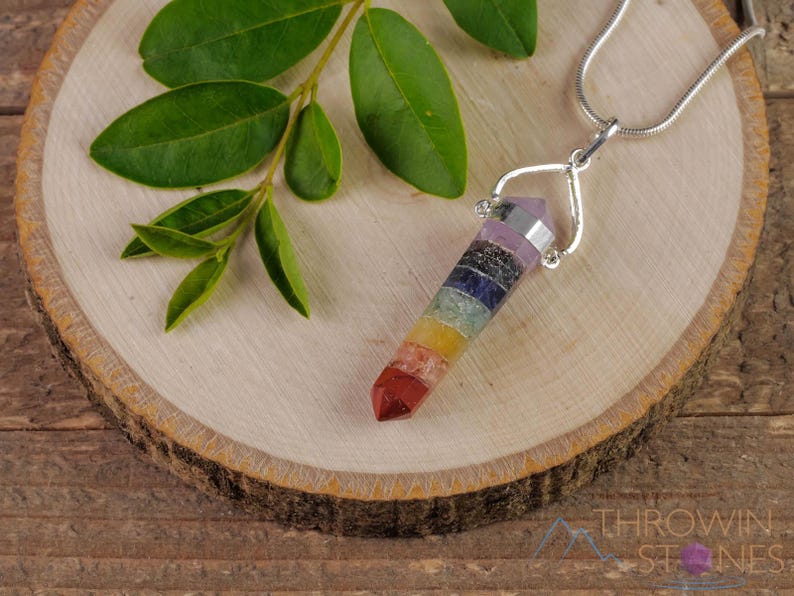 These rainbow chakra crystal pendants are polished double terminated points held in a silver bail.  The points are a composite of different crystals.
Crystals are nature-made therefore each one is unique in appearance.
