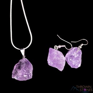 These pale lilac colored Amethyst crystal jewelry sets are raw crystal chunk pendants strung on a silver chain, with matching earrings on silver ear hooks.  
Crystals are nature-made therefore each one is unique in appearance.