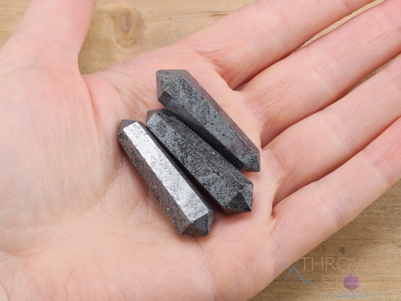 Hematite Mini Crystal Points. These metallic grey miniature wands are double terminated with a polished finish. Each gemstone is unique and will vary in size, shape, and color. These miniature points are great for jewelry making and crystal decor.