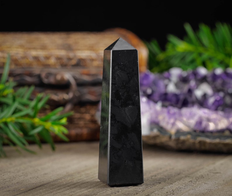 Shungite Crystal Tower. These genuine obelisk shaped crystal carvings are black with a polished finish and are great for crystal grids and decor. Each faceted crystal point is unique and will vary in size, shape, and color. Listing has variations.