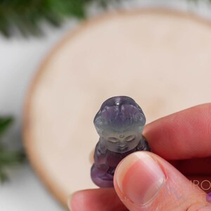 These rainbow Fluorite crystal pendants are carved in the shape of seated Buddha, with a small hole drilled.  Rainbow Fluorite is striated in sheer green, teal, and purple.
Crystals are nature-made therefore each one is unique in appearance.