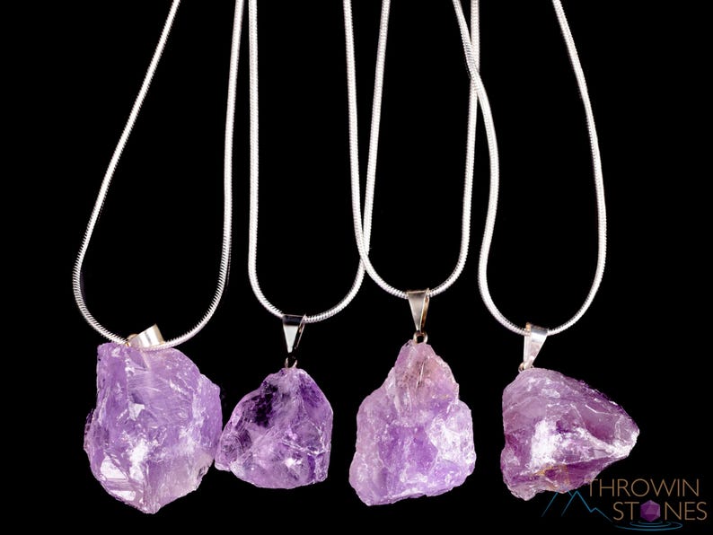 These pale lilac colored Amethyst crystal jewelry sets are raw crystal chunk pendants strung on a silver chain, with matching earrings on silver ear hooks.  
Crystals are nature-made therefore each one is unique in appearance.