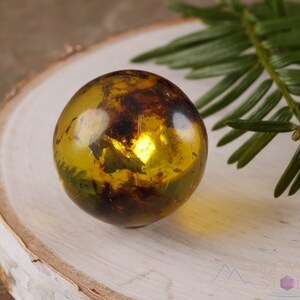 Genuine Amber Crystal Spheres. These semi precious orange crystal balls are between 15 and 40 millimeters in diameter and weigh between 1 and 40 grams. This listing has variations and only medium large and extra large spheres will come with a stand.