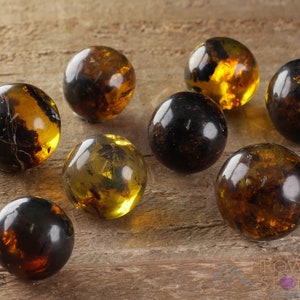 Genuine Amber Crystal Spheres. These semi precious orange crystal balls are between 15 and 40 millimeters in diameter and weigh between 1 and 40 grams. This listing has variations and only medium large and extra large spheres will come with a stand.