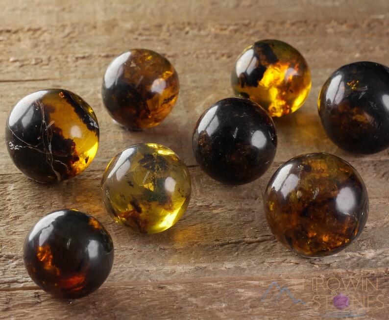 Genuine Amber Crystal Spheres. These semi precious orange crystal balls are between 15 and 40 millimeters in diameter and weigh between 1 and 40 grams. This listing has variations and only medium large and extra large spheres will come with a stand.