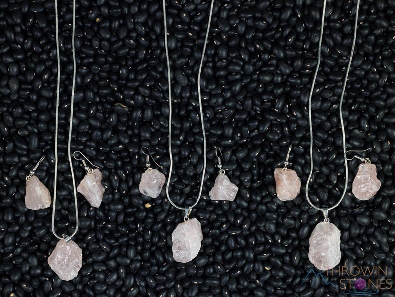 These pale pink Rose Quartz crystal jewelry sets are raw crystal chunk pendants strung on a silver chain, with matching earrings on silver ear hooks.  
Crystals are nature-made therefore each one is unique in appearance.