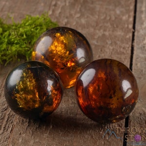 Genuine Amber Crystal Spheres. These semi precious orange crystal balls are between 15 and 40 millimeters in diameter and weigh between 1 and 40 grams. This listing has variations and only medium large and extra large spheres will come with a stand.