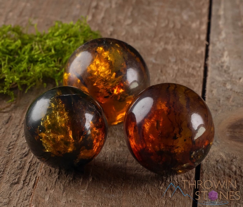 Genuine Amber Crystal Spheres. These semi precious orange crystal balls are between 15 and 40 millimeters in diameter and weigh between 1 and 40 grams. This listing has variations and only medium large and extra large spheres will come with a stand.