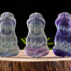These rainbow Fluorite crystal pendants are carved in the shape of seated Buddha, with a small hole drilled.  Rainbow Fluorite is striated in sheer green, teal, and purple.
Crystals are nature-made therefore each one is unique in appearance.