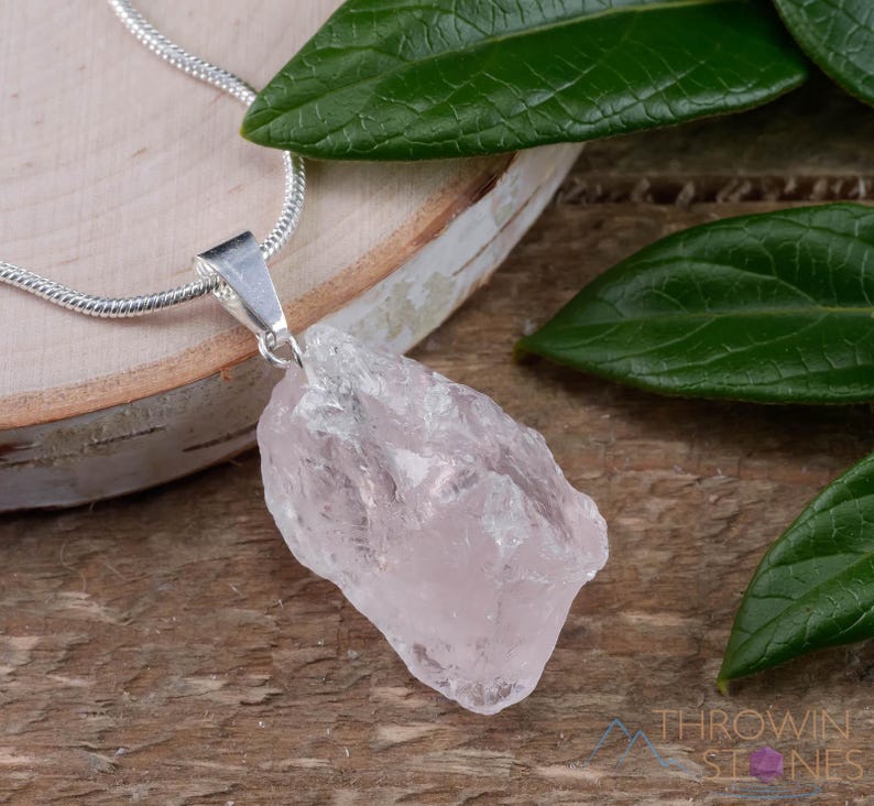 These pale pink Rose Quartz crystal jewelry sets are raw crystal chunk pendants strung on a silver chain, with matching earrings on silver ear hooks.  
Crystals are nature-made therefore each one is unique in appearance.