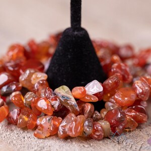 Carnelian chip bracelet. These tumbled chips range in color from orange to red, are drilled and strung on an elastic cord, and create an endless bracelet.