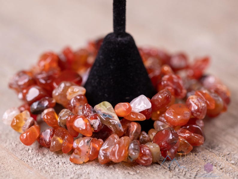 Carnelian chip bracelet. These tumbled chips range in color from orange to red, are drilled and strung on an elastic cord, and create an endless bracelet.