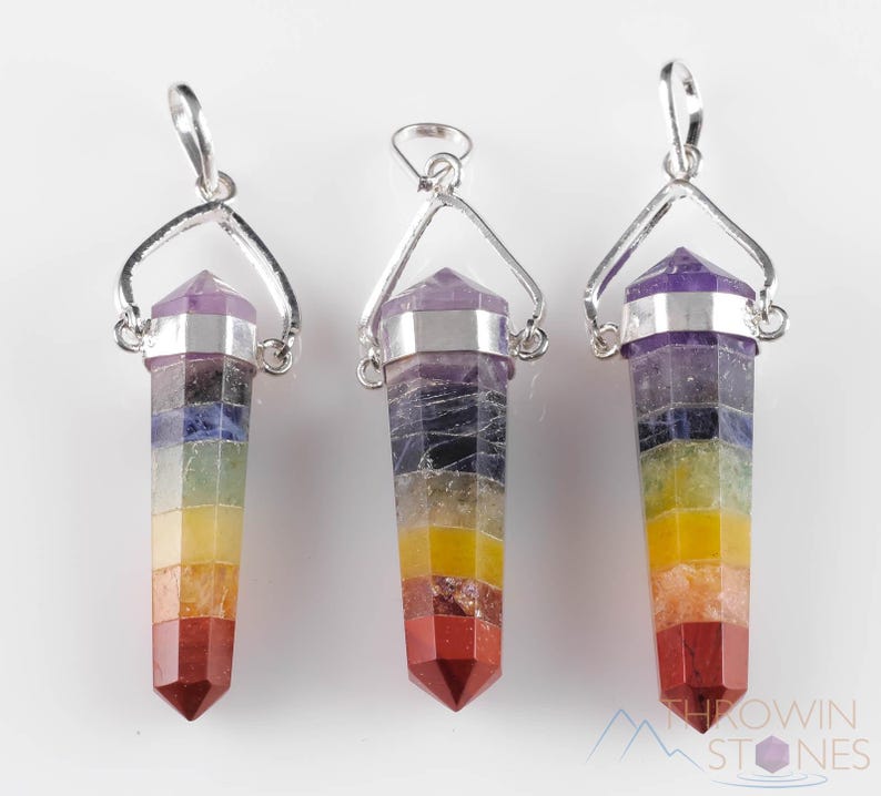 These rainbow chakra crystal pendants are polished double terminated points held in a silver bail.  The points are a composite of different crystals.
Crystals are nature-made therefore each one is unique in appearance.