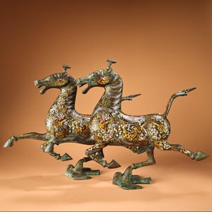 A pair of exquisite and rare Chinese antique hand-crafted bronze inlaid gemstone horse stepping on flying swallow statues