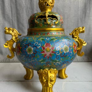 A pair of large, handcrafted copper cloisonné enamel incense burners with animal ears and a Chinese antique.