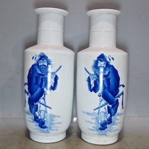 Un par de raros y exquisitos jarrones antiguos chinos con figuras Zhong Kui pintadas a mano en azul y blanco.