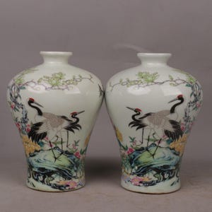 Ein Paar exquisit handbemalte chinesische antike Famille Rose Pflaumen Vasen, die Kiefern und Kraniche darstellen, die den Frühling begrüßen.