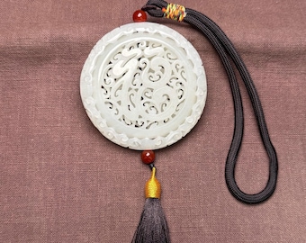 Exquisitely hand-carved Chinese white jade pendant with openwork scrolling floral design.