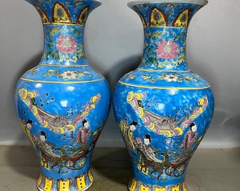 A pair of Chinese antique hand-painted famille rose vases depicting figures and fishtail flowers.