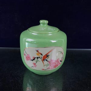 Chinese antique, exquisitely hand-painted green-glazed covered jar with openwork floral and bird design.
