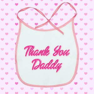 May include: Pink baby bib with a white background and the text "Thank You Daddy" in pink.