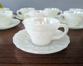 May include: Set of six white iridescent teacups and saucers. The cups and saucers have a scalloped edge and a pearlescent finish.