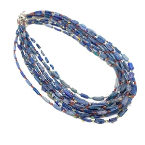 Peut inclure: Un collier multi-rangs compos&eacute; de perles de verre bleues, rouges et vertes. Les perles sont de formes et de tailles diff&eacute;rentes et sont enfil&eacute;es sur une cha&icirc;ne en argent.