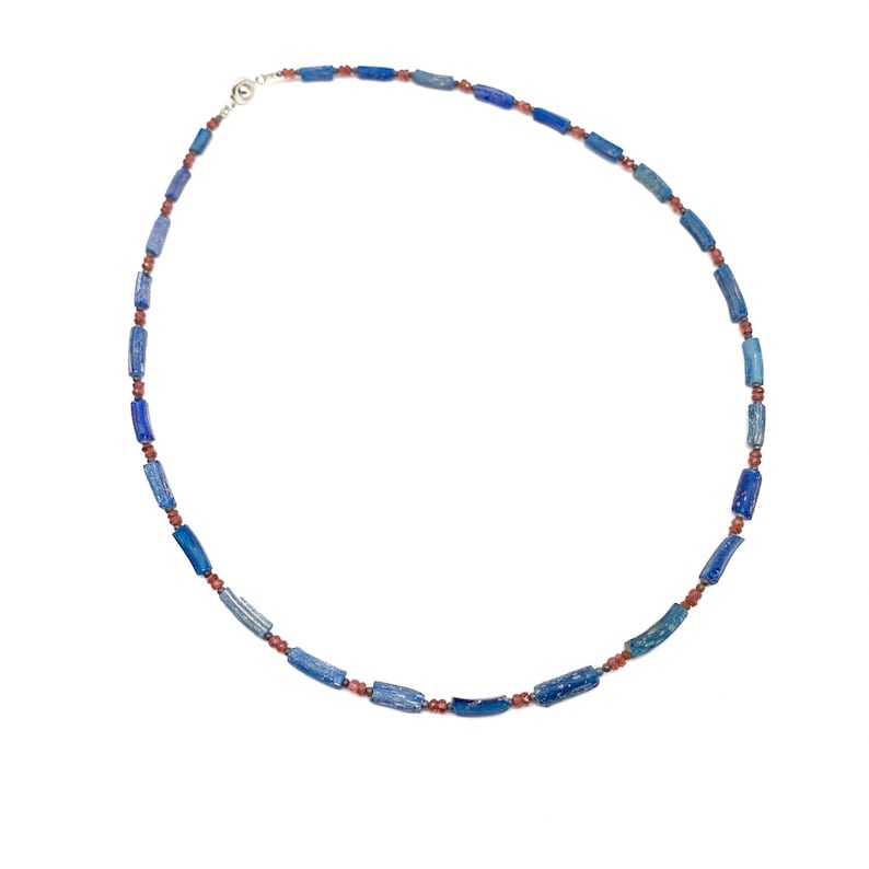 Peut inclure: Un collier compos&eacute; de perles bleues et rouges. Les perles sont de forme rectangulaire et sont enfil&eacute;es sur une cha&icirc;ne en argent.