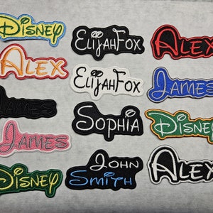 May include: Twelve embroidered iron-on patches with various names, including Disney, Alex, James, Sophia, Elijah Fox, and John Smith. The patches are in various colours, including red, blue, green, yellow, black, and white.