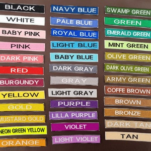 May include: A collection of fabric swatches in various colours, including black, white, pink, red, yellow, gold, purple, blue, green, brown, and tan. The swatches are labelled with the colour name.