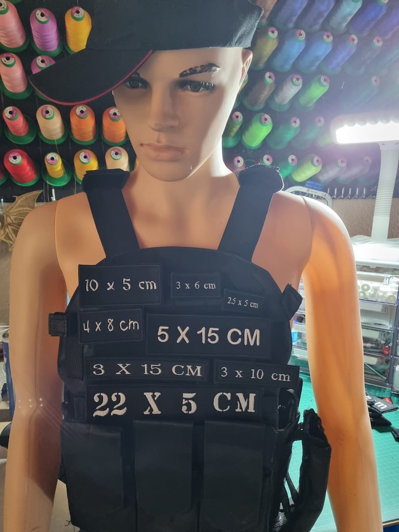 May include: Black tactical vest with multiple white velcro patches, each with different measurements in centimetres. The patches include: 10 x 5 cm, 3 x 6 cm, 2.5 x 5 cm, 4 x 8 cm, 5 x 15 cm, 3 x 15 cm, 3 x 10 cm, and 22 x 5 cm.