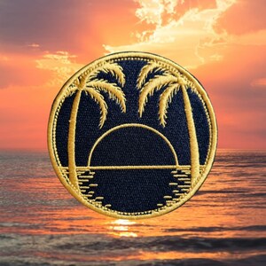 May include: A round, black embroidered patch with a gold outline. The patch features two palm trees and a setting sun over a body of water.
