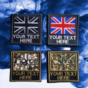May include: Four black patches with white stitching. Each patch features a different Union Jack design. The top left patch has a white Union Jack, the top right patch has a red, white, and blue Union Jack, the bottom left patch has a camouflage Union Jack, and the bottom right patch has a green camouflage Union Jack. Each patch has the text "Your Text Here" printed below the Union Jack.