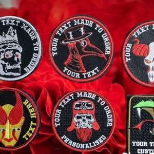 May include: Six embroidered patches with black backgrounds and red, white, and black designs. The patches feature various images, including a skull with a crown, a bird with a beak, a skull with horns, a demon with horns, a skull with a beard, and a snake with fangs. Each patch has the text "Your Text Made To Order" around the edge.
